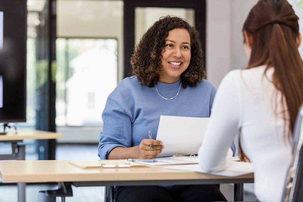 Entretien professionnel entre deux femmes souriantes