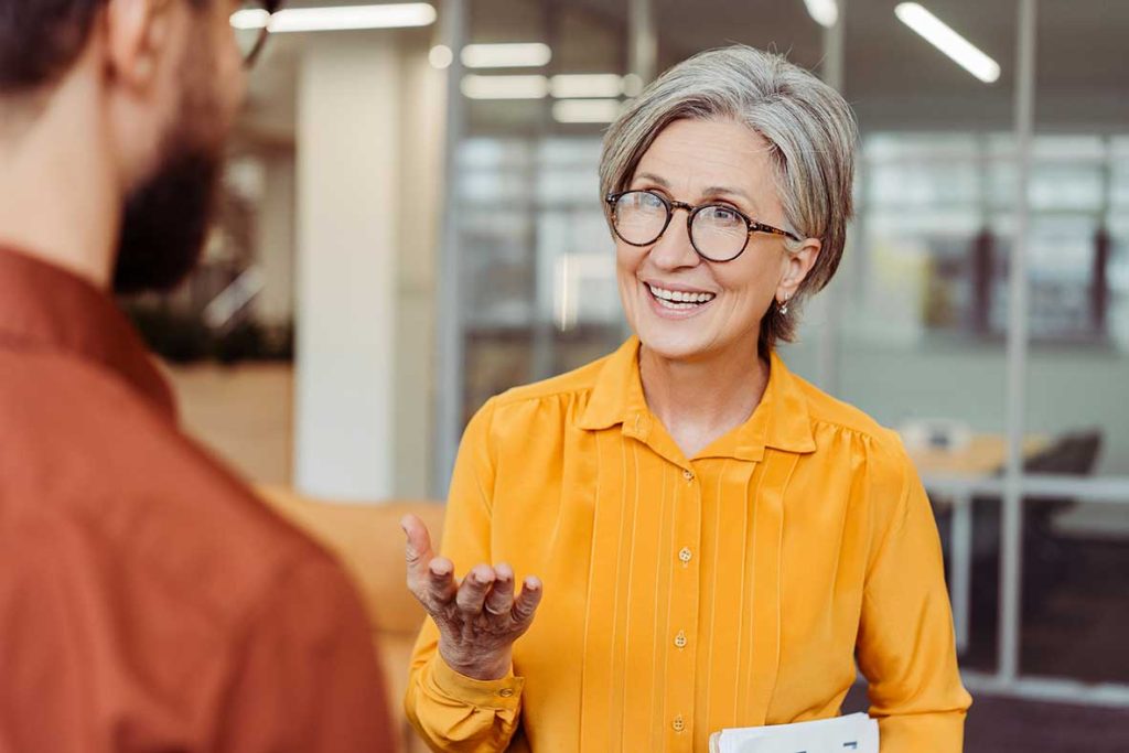 Femme souriante discutant au bureau